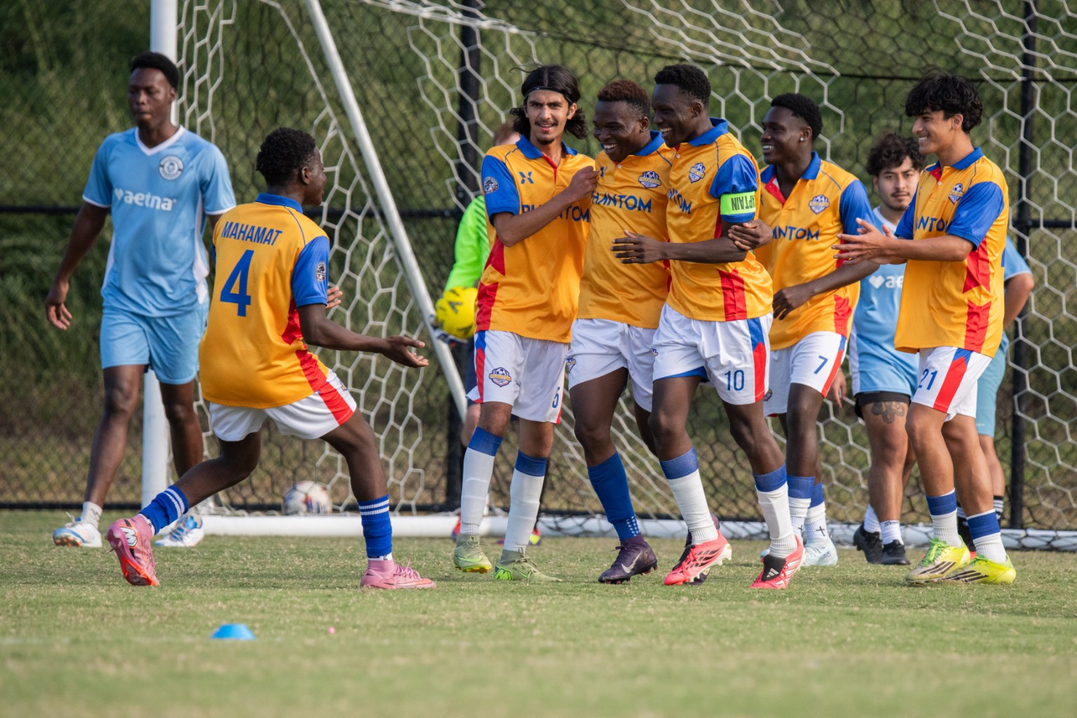 Phantom FC players celebrating together in front of goal
